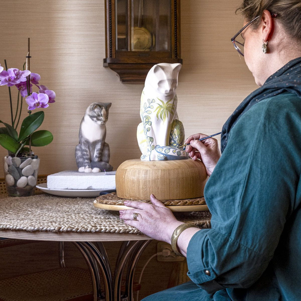 Pulvis artist hand decorating a ceramic cat memorial urn